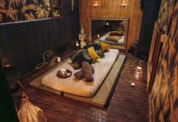 Gay massage in Barcelona at Shada Masajes. Massage room with mattress, pillows, towels, candles, and golden decor for gay men's spa day.