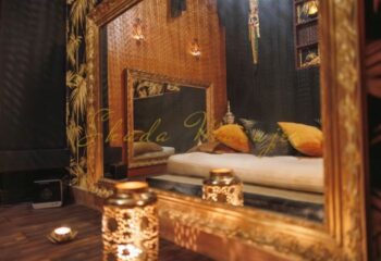 Shada Massage in Barcelona: Reflection of a luxurious gay massage room with gold accents, candles, and plush pillows for a relaxing experience.
