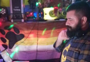 Lisboa Shelter Bar DJ with Bear Brotherhood flag. Gay bar travel advice, nightlife scene. LGBT+ friendly venue in Portugal's capital.