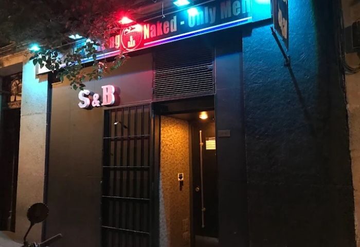 Entrance to S&B, a gay cruise club in Madrid. Neon signs read Naked - Only Men. A popular spot for gay men's nightlife in Madrid.