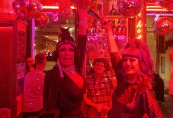 Drag queens at a Lisbon gay bar. Red lighting, disco balls. Gay travel advice. Side Bar Lisbon nightlife.