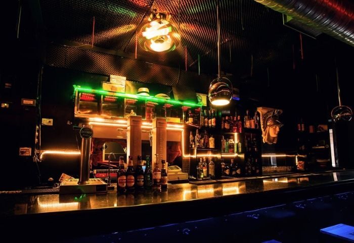 Sixta Bar, a gay bar in Madrid. Interior view of the bar with bottles, glasses, and neon lights. Madrid's gay nightlife scene.