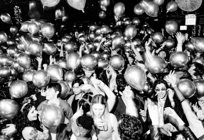 Chicago's Smartbar gay party scene: A black and white shot of a lively crowd with balloons, celebrating at a gay bar.