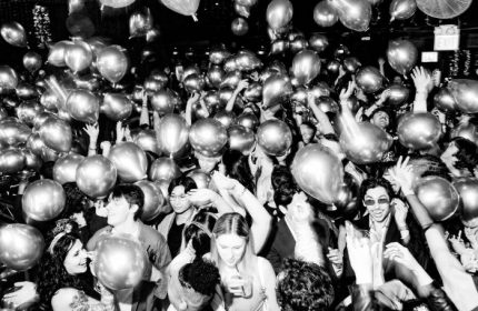 Chicago's Smartbar gay party scene: A black and white shot of a lively crowd with balloons, celebrating at a gay bar.