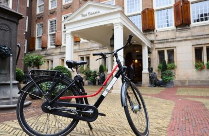 Bike in front of Sofitel Legend The Grand Amsterdam, a luxury gay-friendly hotel on a canal. Best hotel for gay men in Amsterdam.