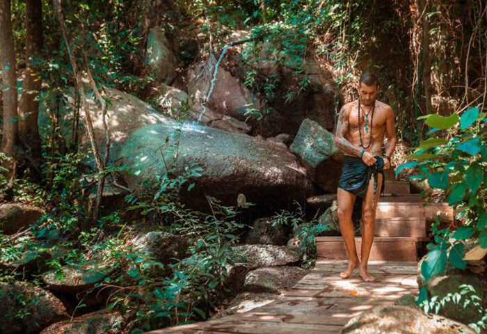 Koh Phangan gay hotels with private beachfront: Man in nature shower at Somewhere Only We Know resort. Gay travel advice.