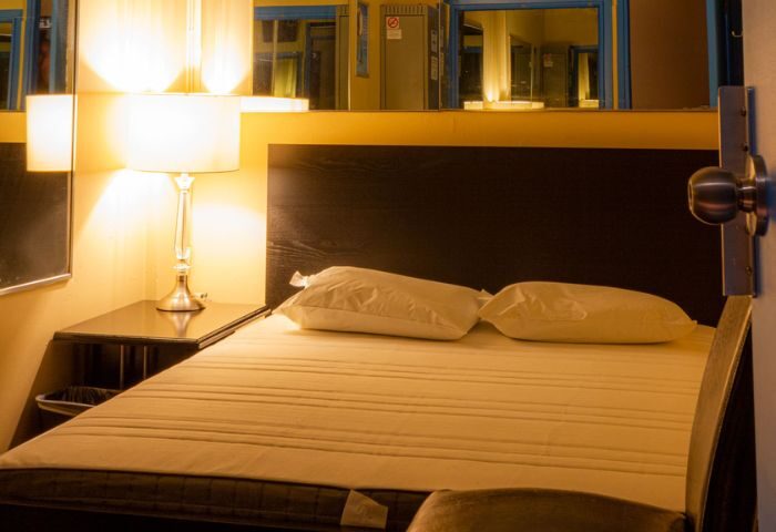 Toronto spa excess room with bed, pillows, lamp, and mirrors. Gay travel advice for relaxation and comfort in Toronto's spa scene.