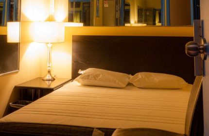 Toronto spa excess room with bed, pillows, lamp, and mirrors. Gay travel advice for relaxation and comfort in Toronto's spa scene.