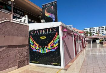 Sparkles Show Bar, a gay bar in Gran Canaria. Exterior view with colorful signage featuring the bar's name and rainbow wings.