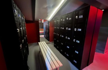 Lockers at Spartacus Gay Sauna in Puerto Vallarta. Black lockers line the wall with a bench in the foreground. Gay travel.