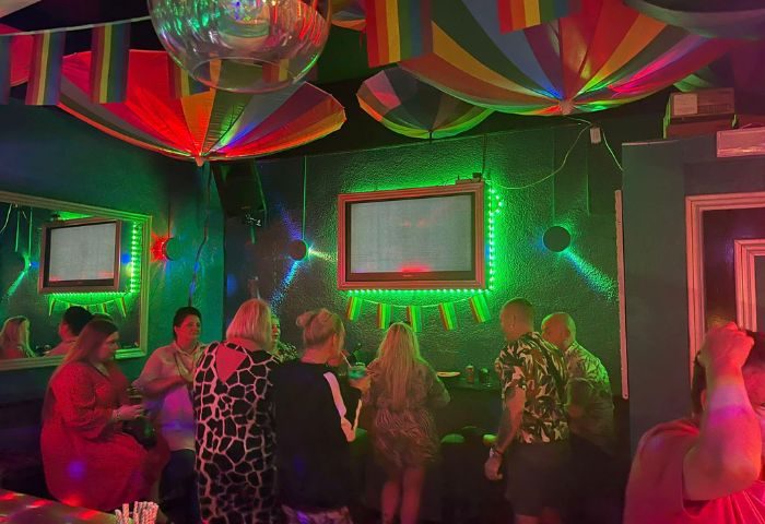 Spirit Bar, a gay bar and party spot in Benidorm. People enjoying the vibrant atmosphere with rainbow decorations and disco ball.