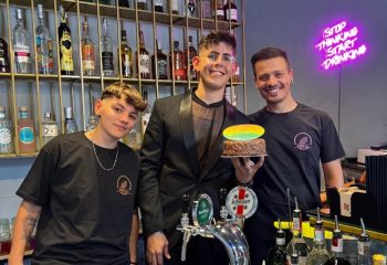 Spiritall Lounge Bar Rome staff. Gay bar with cocktails, beer, and cake. Stop Thinking Start Drinking neon sign. Gay travel advice.