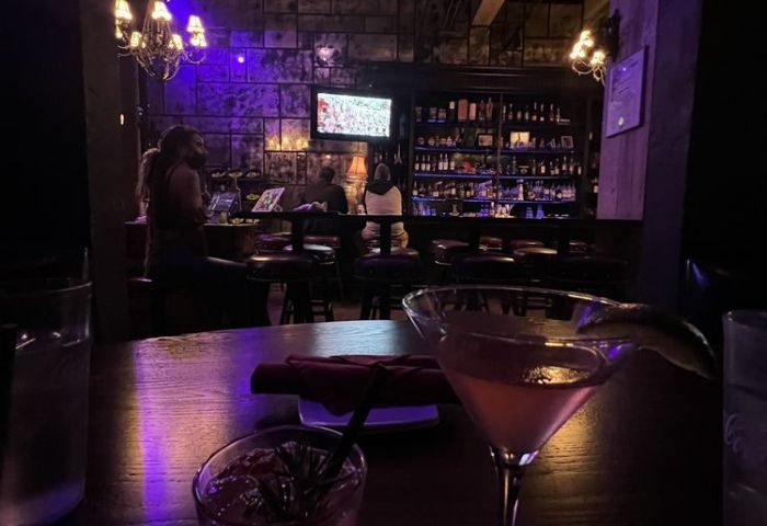 St Felix Hollywood bar interior. Cocktails on table, bar with patrons in background. Gay travel advice for Hollywood nightlife.