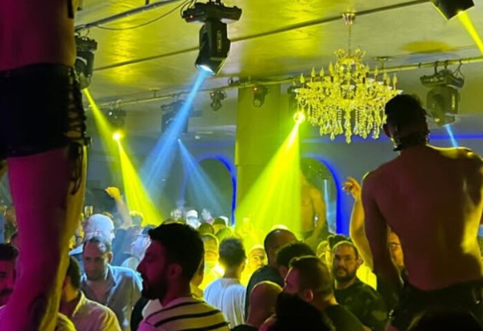 Stay Club Istanbul scene. Gay men crowd, stage lights, and chandelier create a vibrant atmosphere. Gay travel advice.