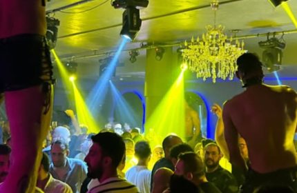 Stay Club Istanbul scene. Gay men crowd, stage lights, and chandelier create a vibrant atmosphere. Gay travel advice.