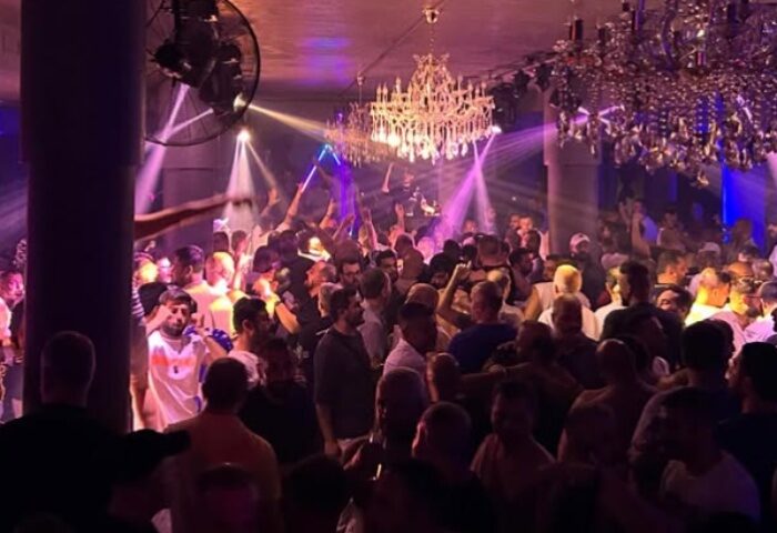 Crowd of gay men dancing at Stay Club Istanbul. Nightlife scene with chandeliers and purple lighting. Gay travel advice for Istanbul.