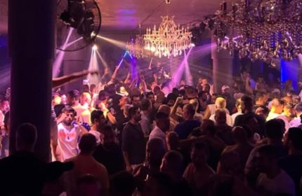 Crowd of gay men dancing at Stay Club Istanbul. Nightlife scene with chandeliers and purple lighting. Gay travel advice for Istanbul.