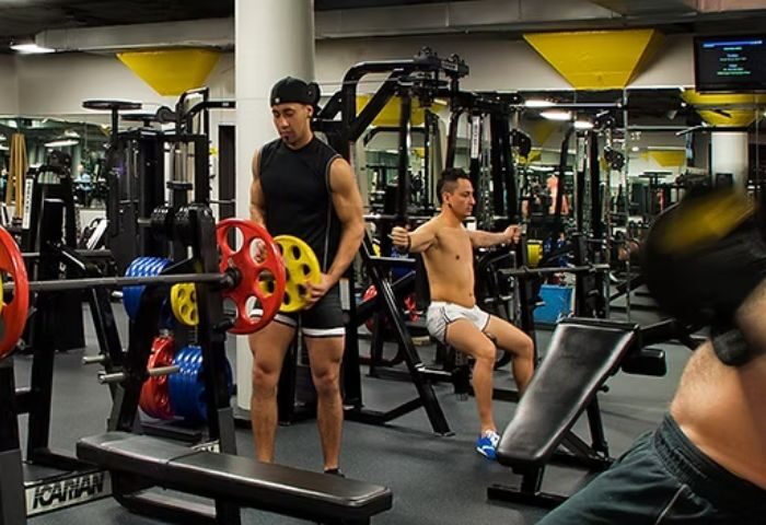 Steamworks Chicago gay gym: Men work out with weights and machines in a modern gym setting. Sauna and fitness for gay men's travel.