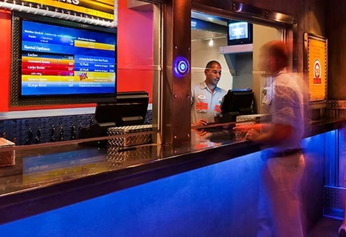 Steamworks Chicago: Front desk at the gay gym and sauna in Chicago. Man checking in at the counter with rental options on the screen.