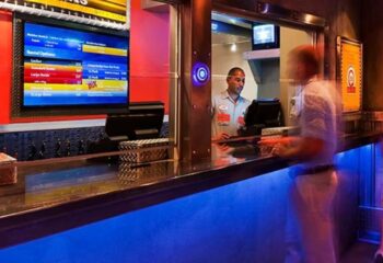 Steamworks Chicago: Front desk at the gay gym and sauna in Chicago. Man checking in at the counter with rental options on the screen.