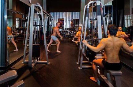 Steamworks Vancouver gym. Gay sauna in Vancouver with men working out on weight machines, shirtless, in shorts. Gay travel.
