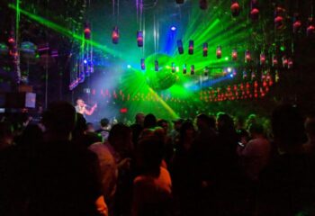 Stereo Bar gay party in Montreal. Crowd of people, stage with singer, disco ball and laser lights. Gay travel advice.