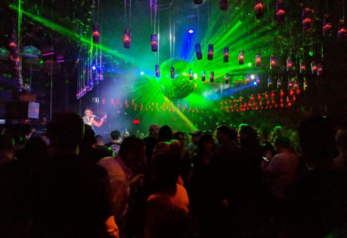 Stereo Bar gay party in Montreal. Crowd of people, stage with singer, disco ball and laser lights. Gay travel advice.