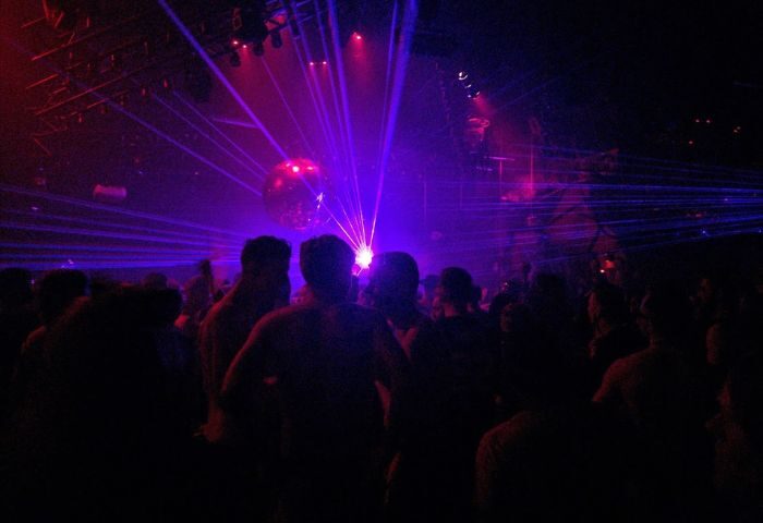 Montreal gay party at Stereo Bar. Crowd of men under disco ball and lasers. Gay nightlife travel advice.