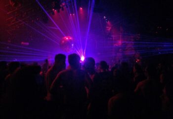 Montreal gay party at Stereo Bar. Crowd of men under disco ball and lasers. Gay nightlife travel advice.