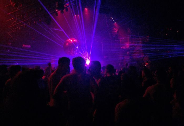 Montreal gay party at Stereo Bar. Crowd of men under disco ball and lasers. Gay nightlife travel advice.
