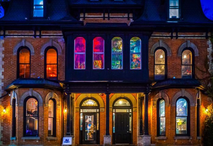 Storm Crow Manor in Toronto, Canada. Brick building with colorful stained glass windows. Gay travel destination for unique dining.