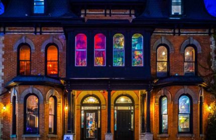 Storm Crow Manor in Toronto, Canada. Brick building with colorful stained glass windows. Gay travel destination for unique dining.