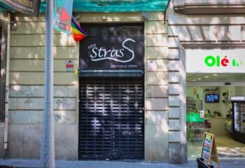 Strass Barcelona Gay Bar in Barcelona. Exterior of Strass gay bar with closed shutters. Rainbow flag visible. Gay travel advice.