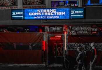 Strong Construction gay cruise club in Gran Canaria. Men's cruising bar exterior with OPEN sign. Gay travel destination.