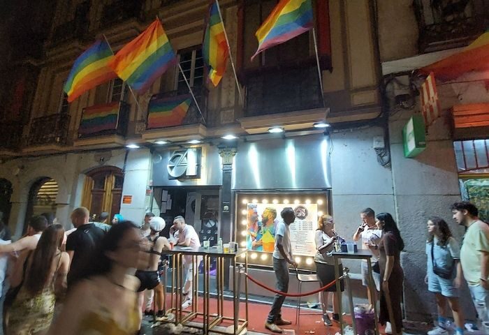 Studio 54 Madrid gay bar entrance. Rainbow flags adorn the facade. People gather outside, enjoying the vibrant nightlife. Gay travel.