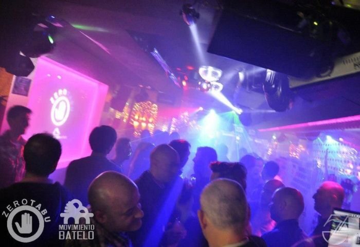 Crowd at Studio 54 Madrid gay bar. People dancing under colorful lights. Gay nightlife travel destination in Spain. Nightclub scene.