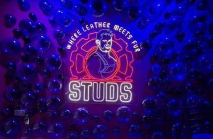 Neon sign for Studs Bear Bar, a gay place in Puerto Vallarta. It features a bear in leather harness and the words Where leather meets fur.
