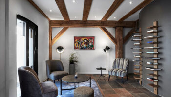 Stylish luxury at 71 Nyhavn Hotel, Copenhagen. Gay-friendly hotel lounge area with exposed beams, modern furniture, and a unique bookshelf.