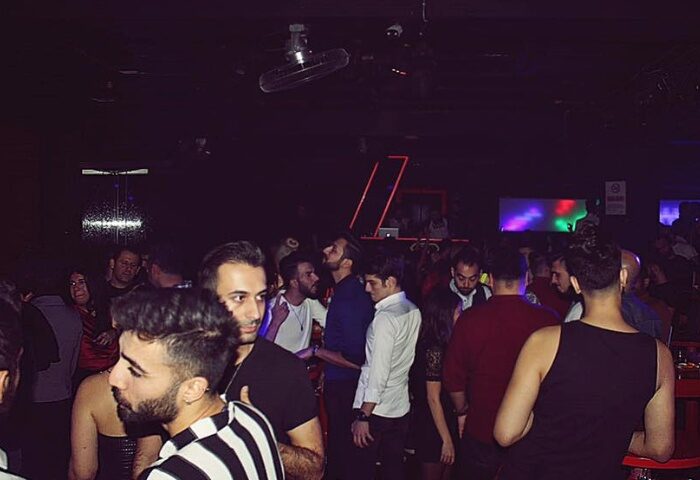 SuperFabric Club Istanbul: Gay nightlife scene with a crowd of men in a dimly lit club, enjoying the vibrant atmosphere.