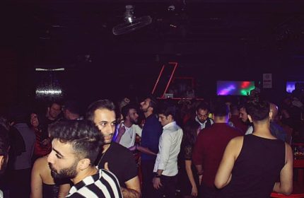SuperFabric Club Istanbul: Gay nightlife scene with a crowd of men in a dimly lit club, enjoying the vibrant atmosphere.
