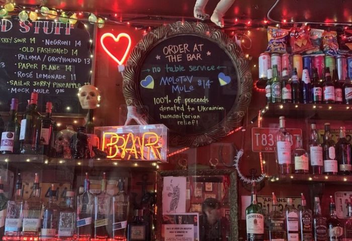Sweaty Betty's Bar in Toronto: A quirky, gay-friendly bar with neon lights, cocktail menu, and Ukrainian relief fundraiser. Gay travel advice.