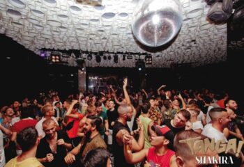 Gay party at TANGA! Shakira gay club in Barcelona. Crowd of men dancing under disco ball. Barcelona gay nightlife.