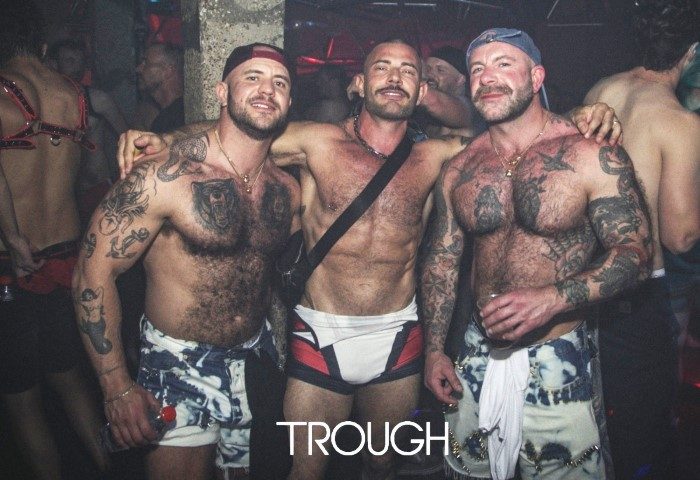 Shirtless men at TROUGH, London's gay party. Muscular men with tattoos pose at the Saturday night extravaganza. Nightlife scene.
