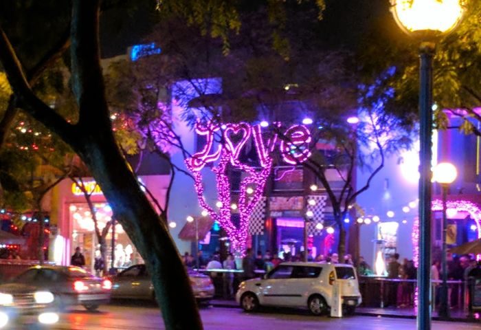 Night scene of TRUNKS, a gay bar. Love sign in pink lights, streetlights, cars, and people. Gay travel destination. TRUNKS.jpg