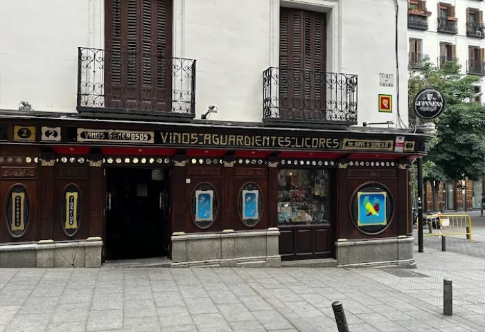 Taberna de Ángel Sierra, a gay bar in Madrid. The tavern's facade features dark wood, vintage signage, and small balconies above. Guinness sign.