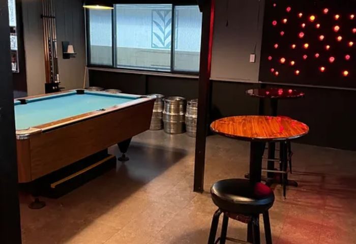 Interior of Waikiki gay bar in Honolulu: Pool table, bar stools, and kegs. Tapas bar with drinks, a popular gay travel destination.
