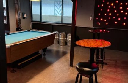 Interior of Waikiki gay bar in Honolulu: Pool table, bar stools, and kegs. Tapas bar with drinks, a popular gay travel destination.