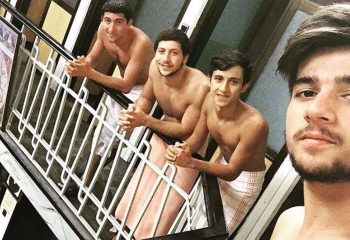 Gay travel: Four shirtless men in towels at Tarihi Galatasaray Hamami, Istanbul. Turkish bath experience, gay-friendly travel destination.