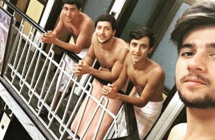 Gay travel: Four shirtless men in towels at Tarihi Galatasaray Hamami, Istanbul. Turkish bath experience, gay-friendly travel destination.