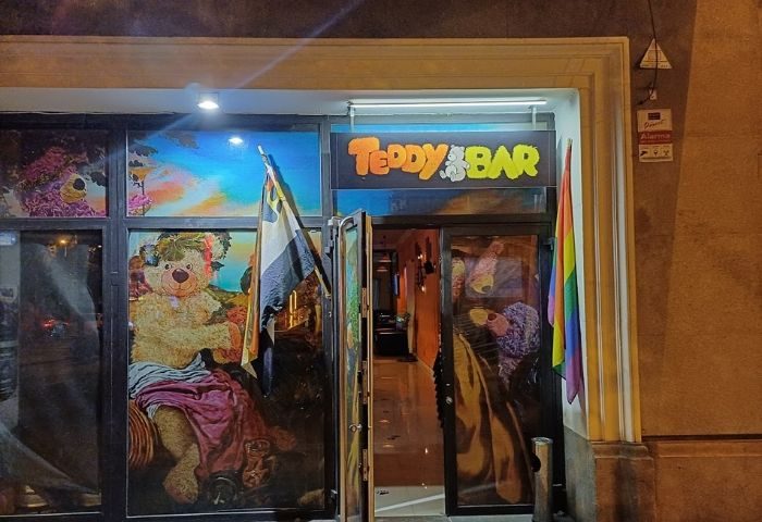 Entrance to Teddy Bar, a gay bar in Barcelona. Rainbow flag and teddy bear art on windows. Gay travel advice destination.